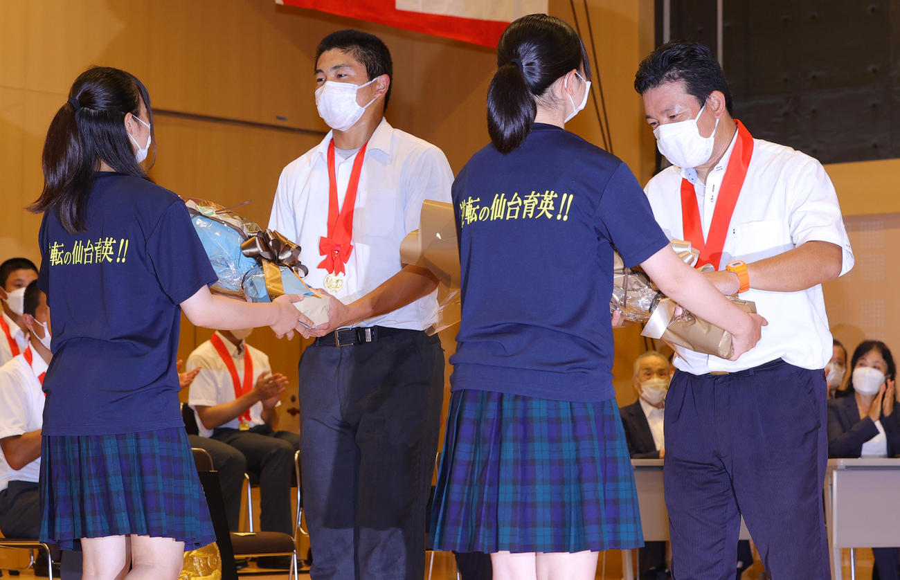 仙台に到着し、宮城野校舎で行われた優勝報告会で花束を受け取る仙台育英・佐藤主将（左）と須江監督（撮影・野上伸悟）