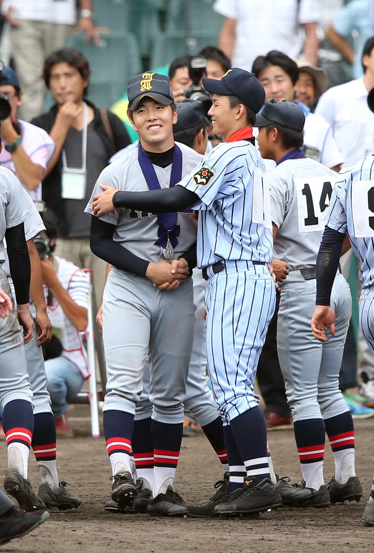 閉会式後の記念撮影を終え、握手を交わす仙台育英・佐藤（左）と東海大相模・小笠原