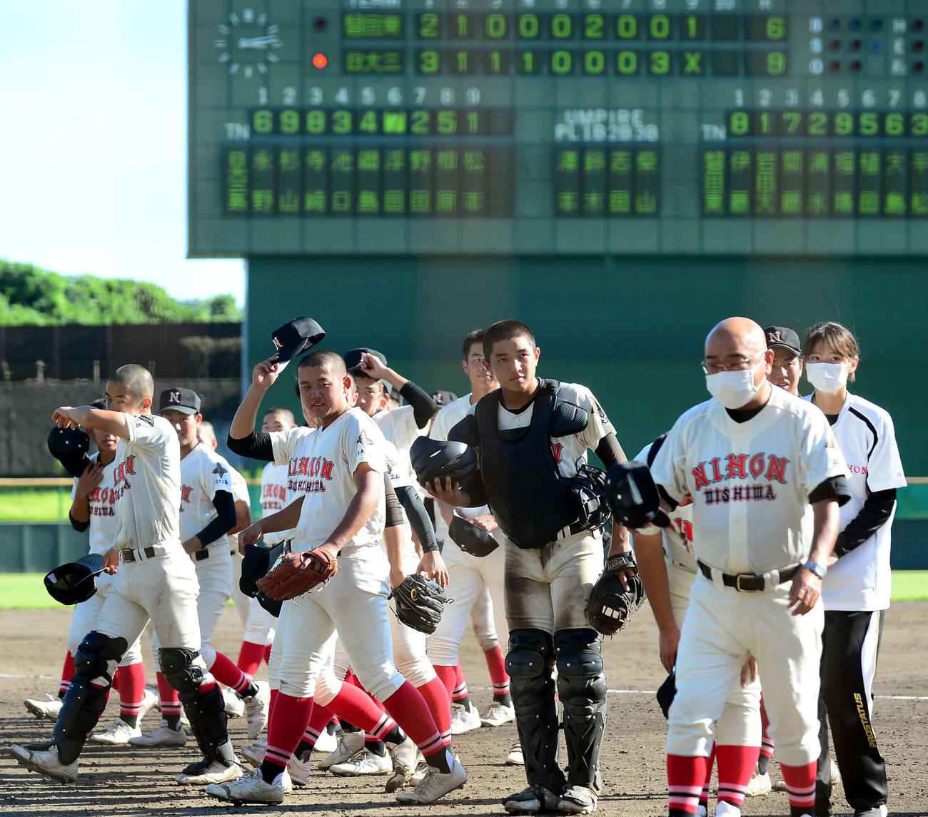 あいさつを終え、引き揚げる日大三島の選手らと永田監督（右手前）