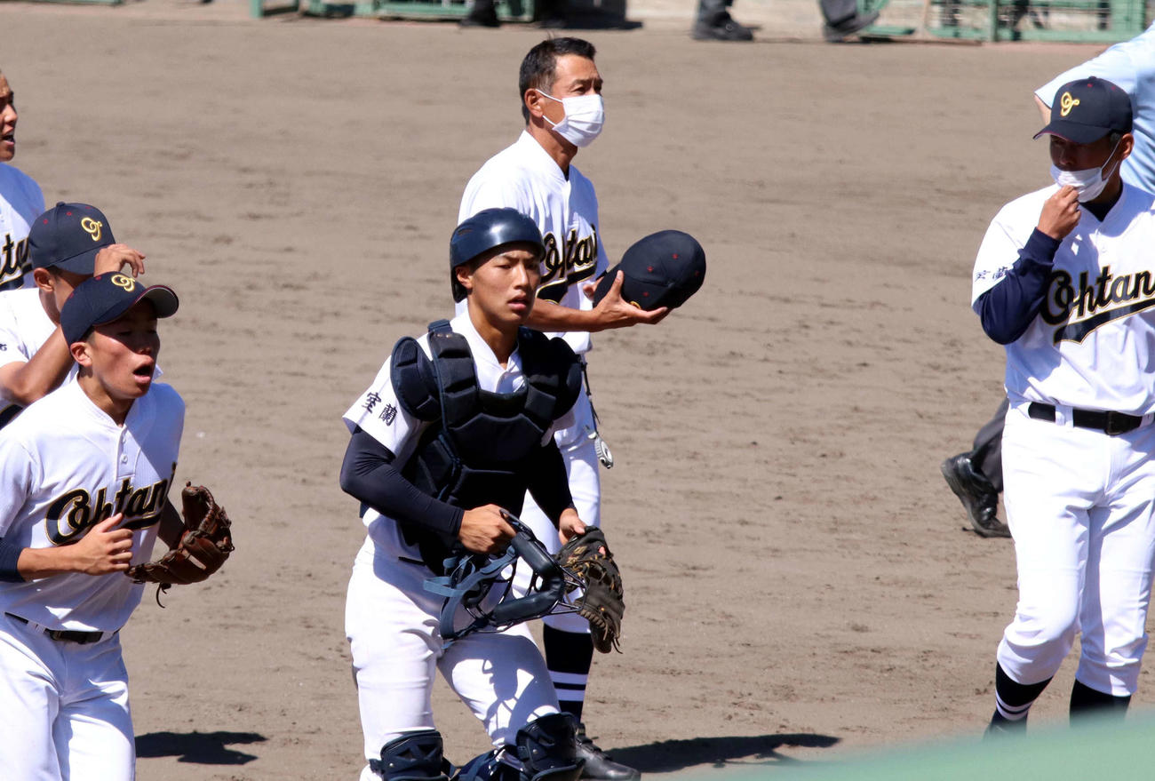浦河対北海道大谷室蘭　試合後のあいさつを終えベンチに引き揚げる北海道大谷室蘭の坂本捕手（中央）と坂本監督（中央奥）（撮影・永野高輔）