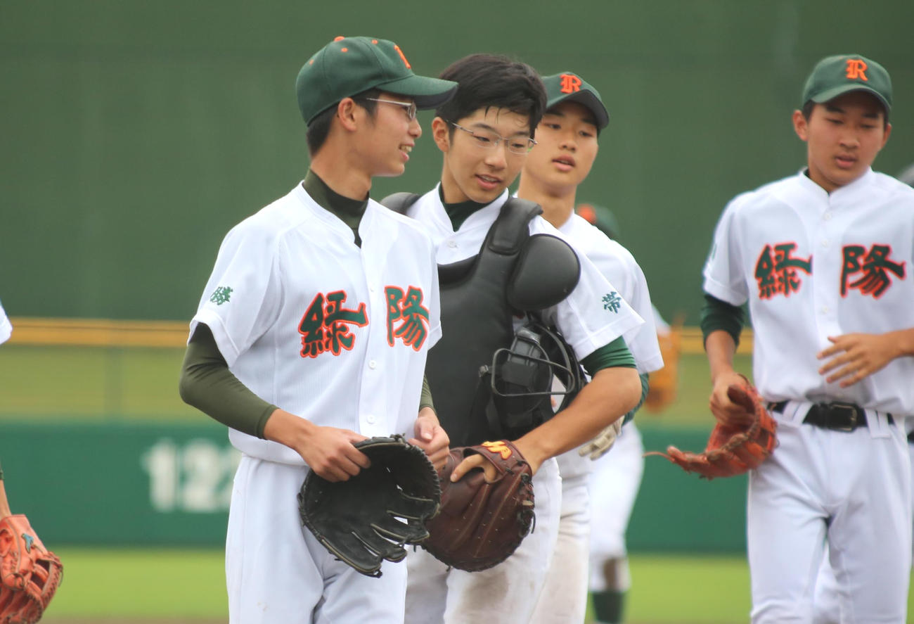 帯広緑陽の田中捕手（左から2人目）は9回完投した渡辺投手（左）をねぎらう