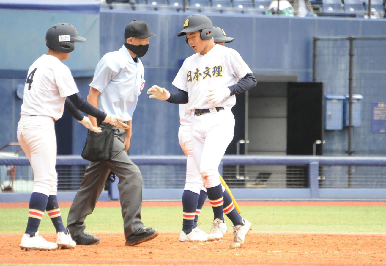 4回裏、右翼に2ランを放った日本文理・宇野がチームメートに迎えられて生還