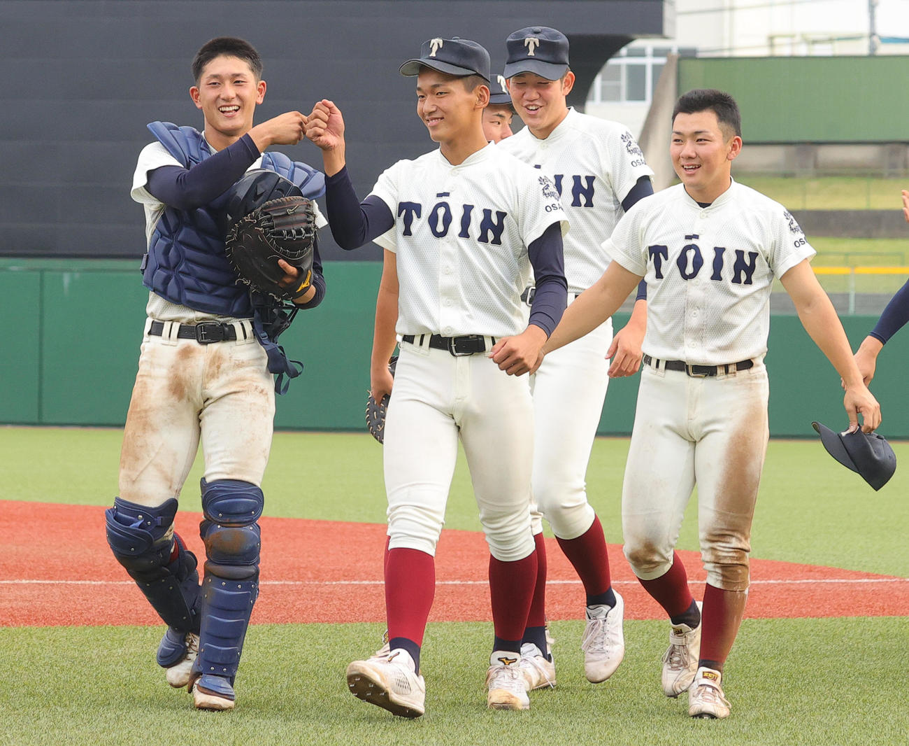 下関国際対大阪桐蔭　捕手の松尾汐恩（左端）とグータッチしながら引き揚げる大阪桐蔭先発の前田。後方右から星子主将、別所（撮影・野上伸悟）