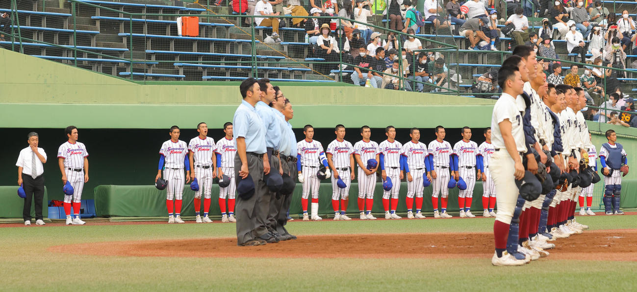 下関国際対大阪桐蔭　3決勝進出を逃し、校歌斉唱時にベンチ前に整列する下関国際の選手たち。左から2人目は坂原監督（撮影・野上伸悟）