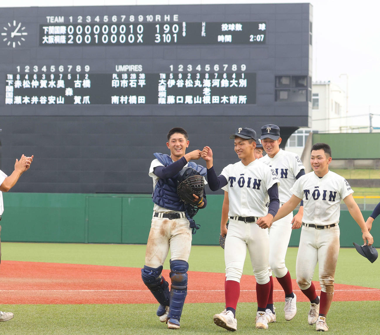 捕手の松尾（左）とグータッチしながら引き揚げる大阪桐蔭先発の前田（撮影・野上伸悟）