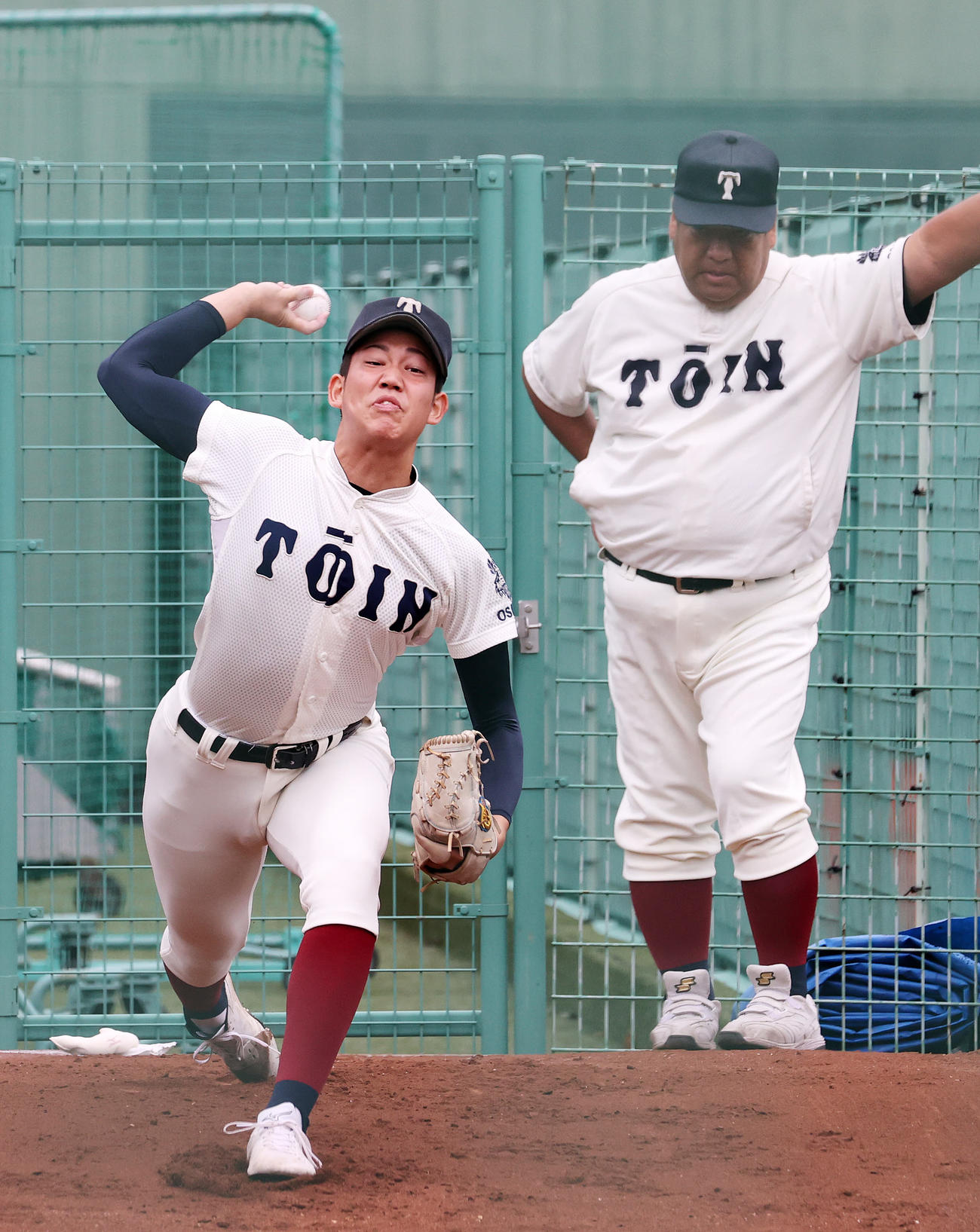 聖光学院対大阪桐蔭　試合前、ブルペンで投球練習する大阪桐蔭・川原（左）、右は西谷監督（撮影・鈴木正人）