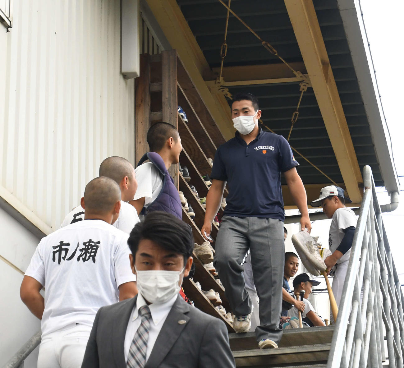 巨人岸スカウト（手前）らとの約1時間の面談を終え、室内練習場から姿を現した高松商・浅野