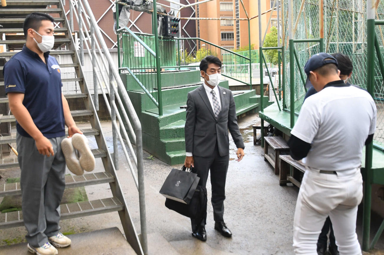 巨人岸スカウト（中央）らとの約1時間の面談を終え、室内練習場から姿を現した高松商・浅野（左）。右は長尾監督