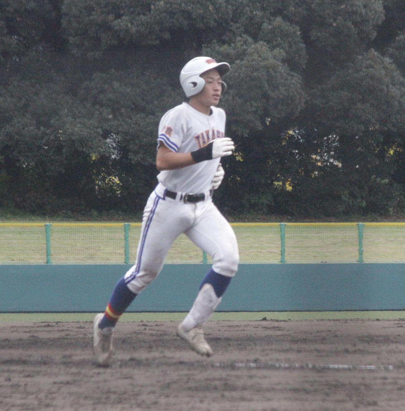 橿原対高田商　高田商の北嶋悠輝捕手は5回、左翼に本塁打を放って生還した（撮影・酒井俊作）