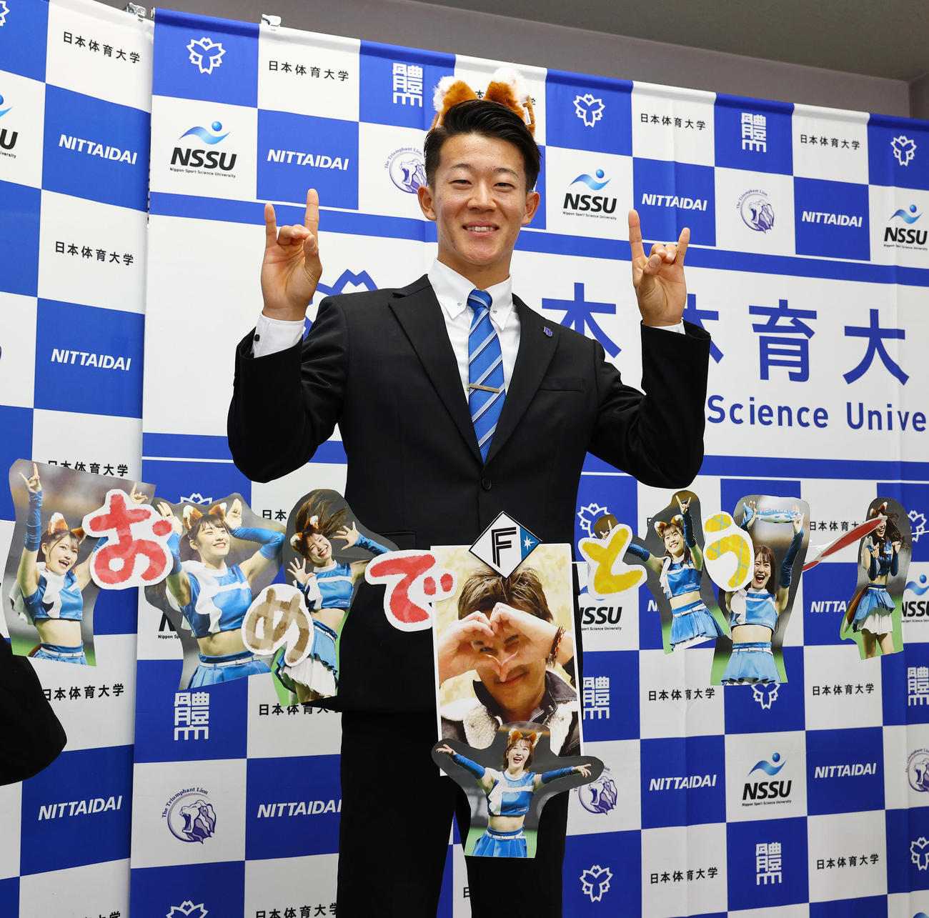 日本ハムから1位指名を受けた日体大・矢沢はキツネポーズで笑顔で写真に納まる（撮影・垰建太）