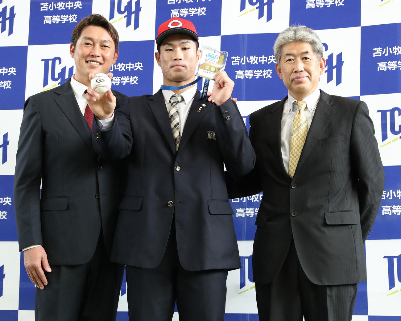 指名あいさつを終え笑顔で撮影に応じる左から広島新井新監督、ドラフト1位指名をされた苫小牧中央の斉藤、近藤スカウト（撮影・佐藤翔太）