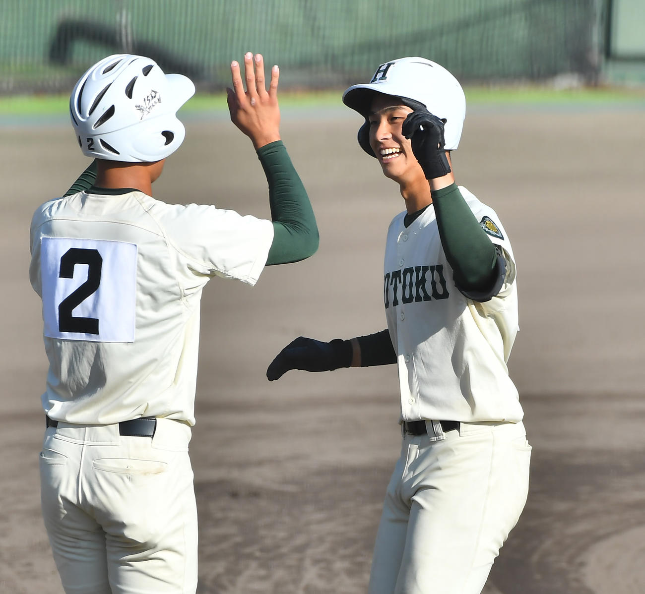報徳学園対箕面学園　4回、左越え3点本塁打を放ち笑顔で生還する報徳学園・石野（右）（撮影・清水貴仁）