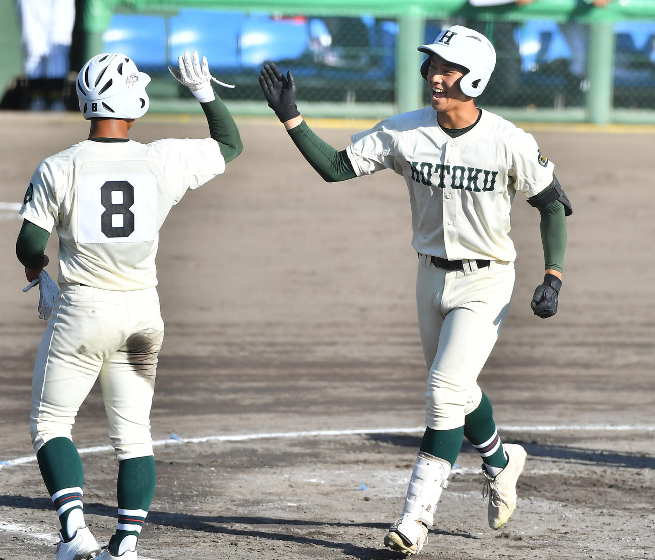 報徳学園対箕面学園　4回、左越え3点本塁打を放ち笑顔で生還する報徳学園・石野（右）（撮影・清水貴仁）