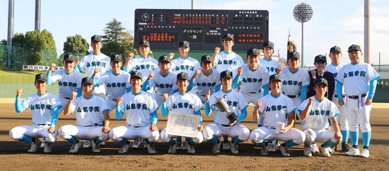 山梨学院対専大松戸　優勝し記念写真に納まる山梨学院の選手たち。後列右から吉田洸二監督、吉田健人部長（撮影・野上伸悟）