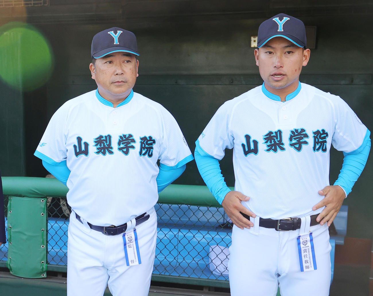 山梨学院対専大松戸　優勝し表彰式式でベンチ前に並ぶ山梨学院・吉田洸二監督（左）と吉田健人部長の親子（撮影・野上伸悟）