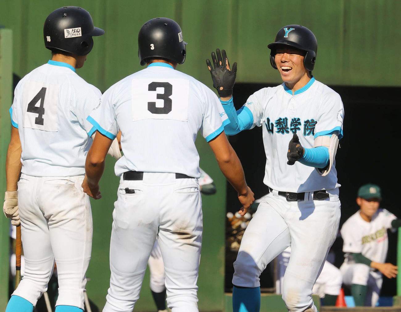 山梨学院対専大松戸　9回表山梨学院2死一、二塁、左越え3点本塁打を放った佐仲（右）は、前の打者で申告敬遠された高橋（中央）、大森に迎えられ笑顔（撮影・野上伸悟）