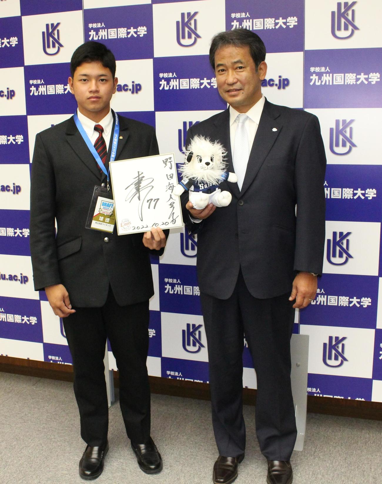 ドラフト会議のIDパス、松井稼頭央監督の直筆サインを手に笑顔の西武ドラフト3位の九州国際大付・野田海人捕手。右は西武の球団本部編成グループディレクター・潮崎哲也（撮影・菊川光一）