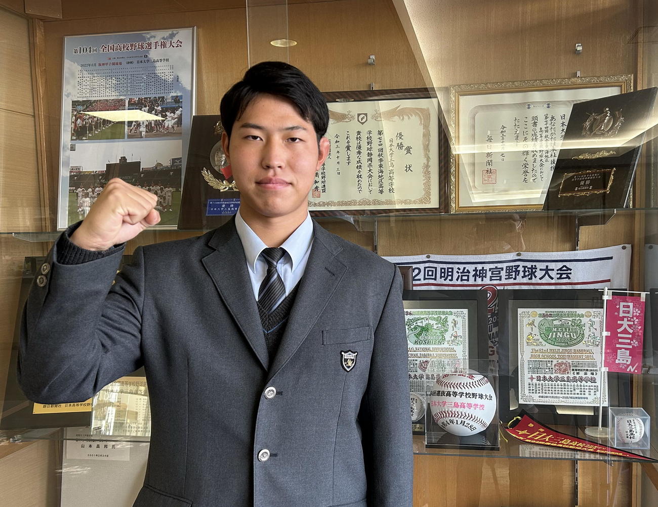 野球部の賞状などが飾られた棚の前で決意を新たにする日大三島・加藤