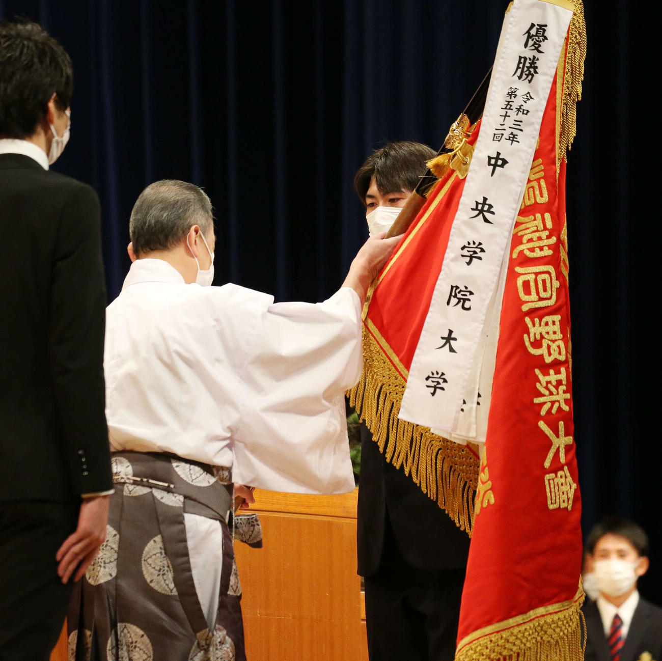 明治神宮野球大会開会式で優勝旗を返還する大学の部、前年度優勝の中央学院・下山（撮影・宮地輝）
