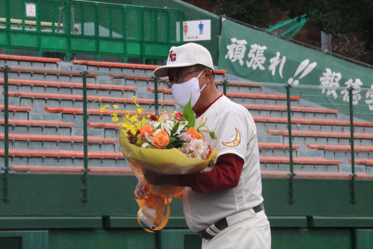 関西学院対報徳学園　広岡正信監督は花束を受け取り、笑顔を見せる（撮影・林亮佑）＝2022年11月26日、明石トーカロ