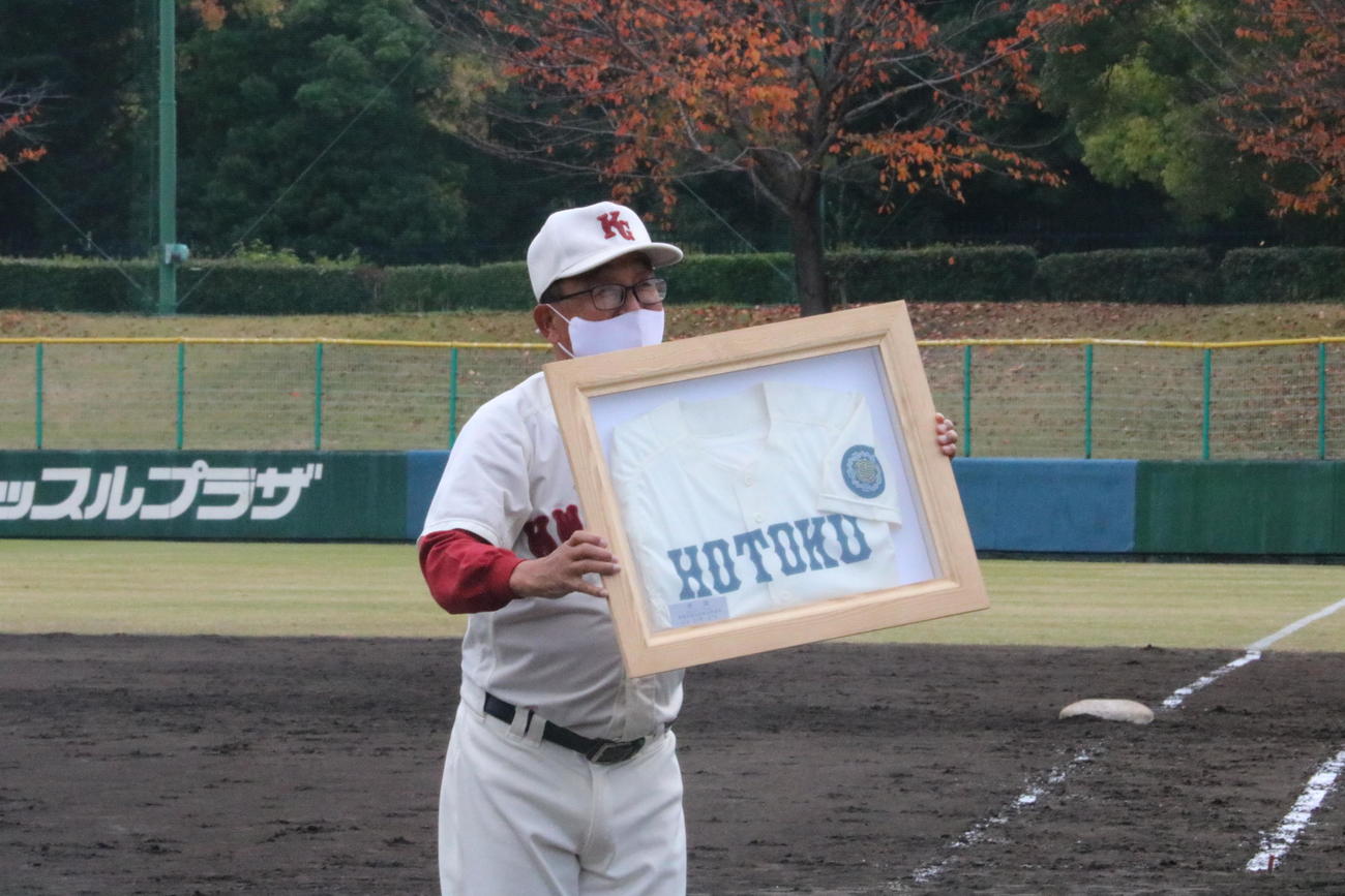 関西学院対報徳学園　関西学院の広岡正信監督は報徳のユニホームを受け取る（撮影・林亮佑）＝2022年11月26日、明石トーカロ