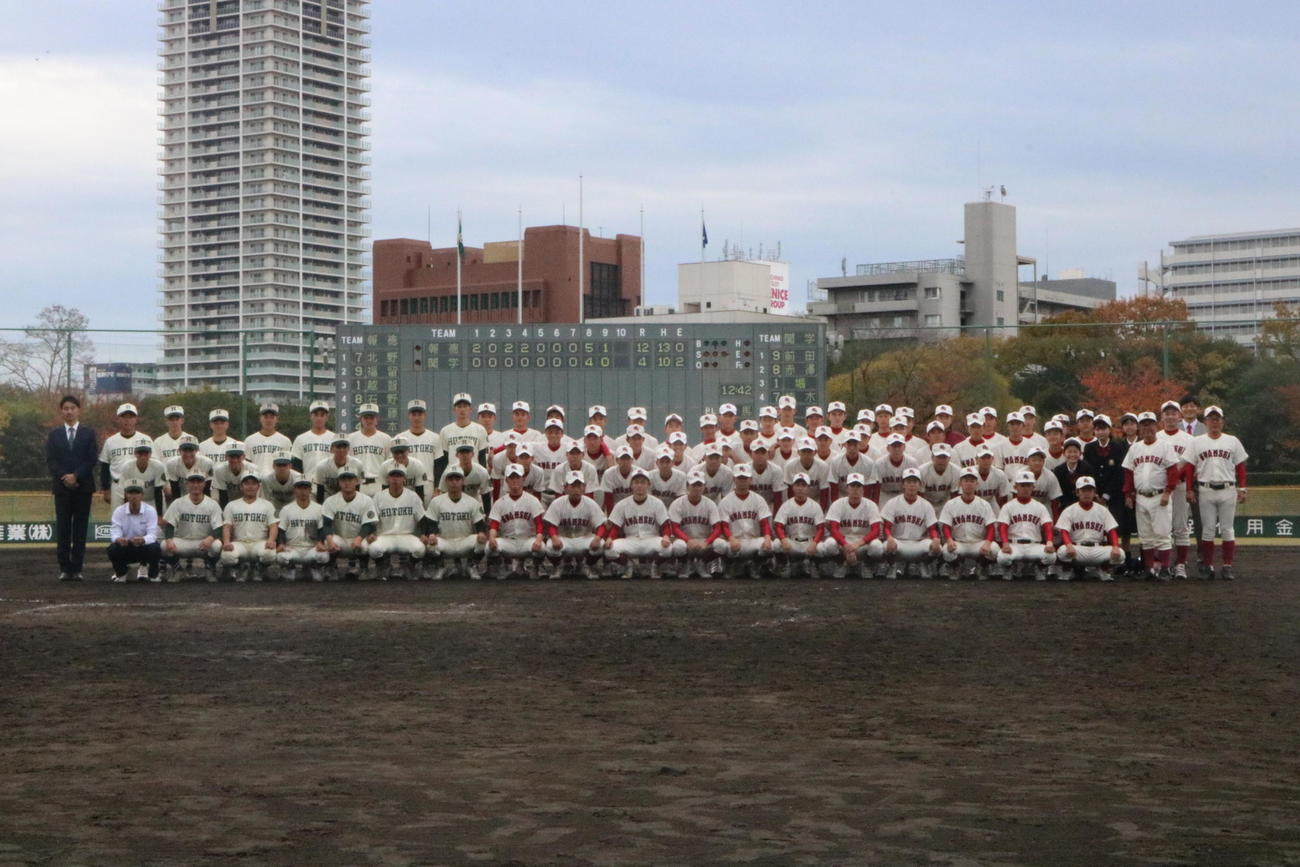 関西学院対報徳学園　試合後に広岡正信監督（右から4人目）は関西学院ナインと報徳ナインと集合写真に収まる（撮影・林亮佑）＝2022年11月26日、明石トーカロ