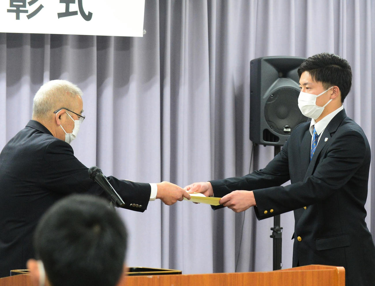 賞状を受け取る佐藤前主将（右）