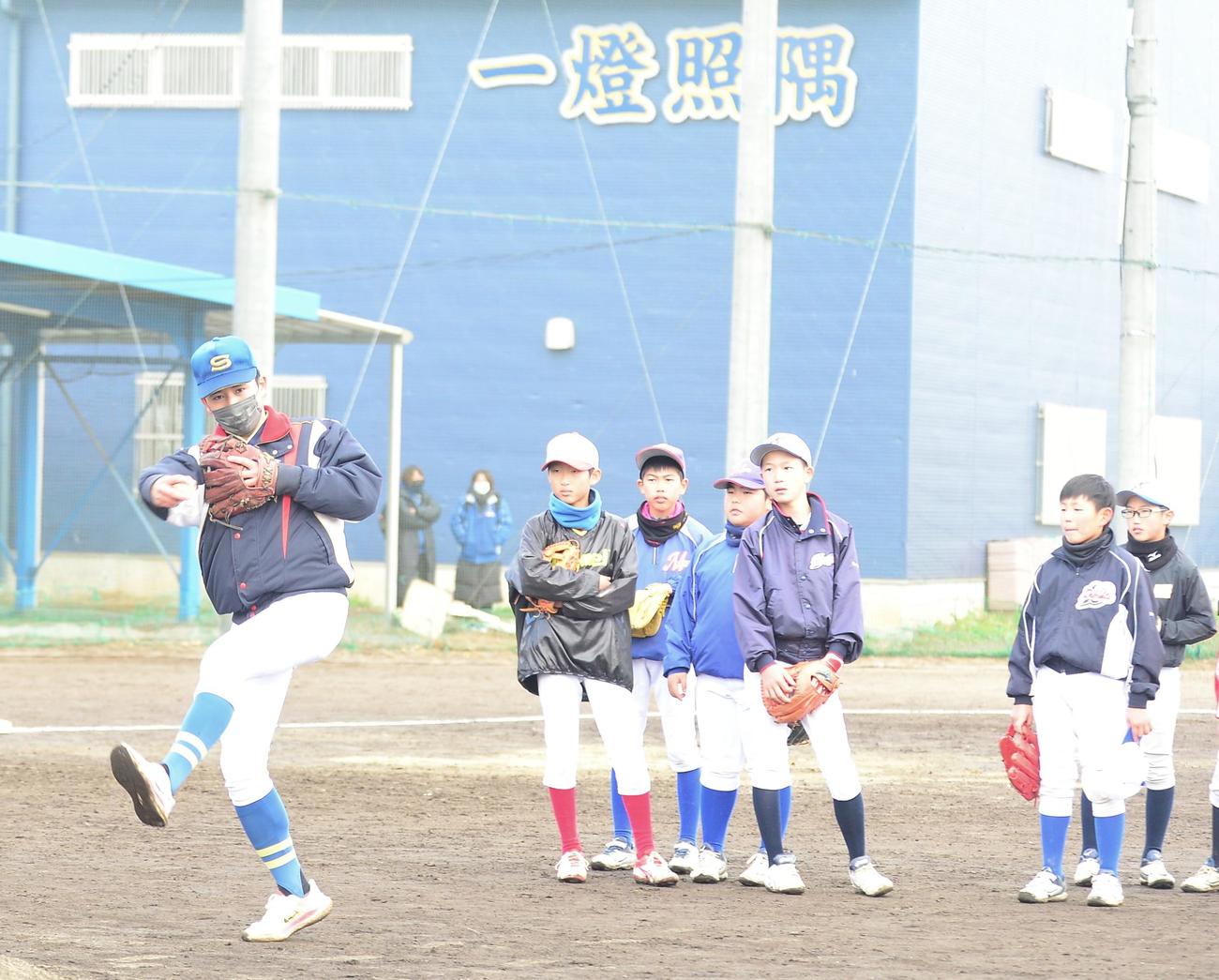 ランニングスローを小学生らに伝授する聖光学院・赤堀（左）