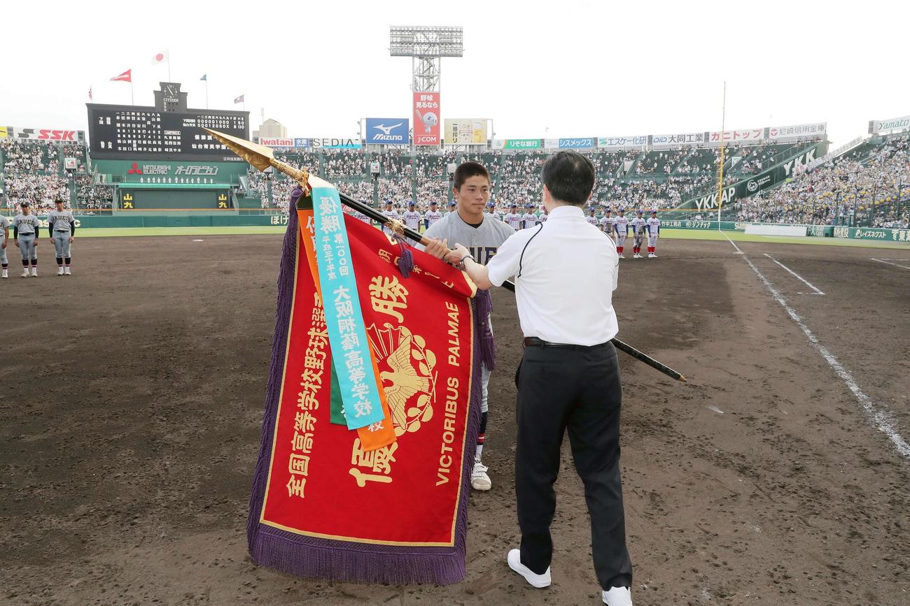 8月、全国制覇を果たし、優勝旗を受け取る佐藤悠斗主将