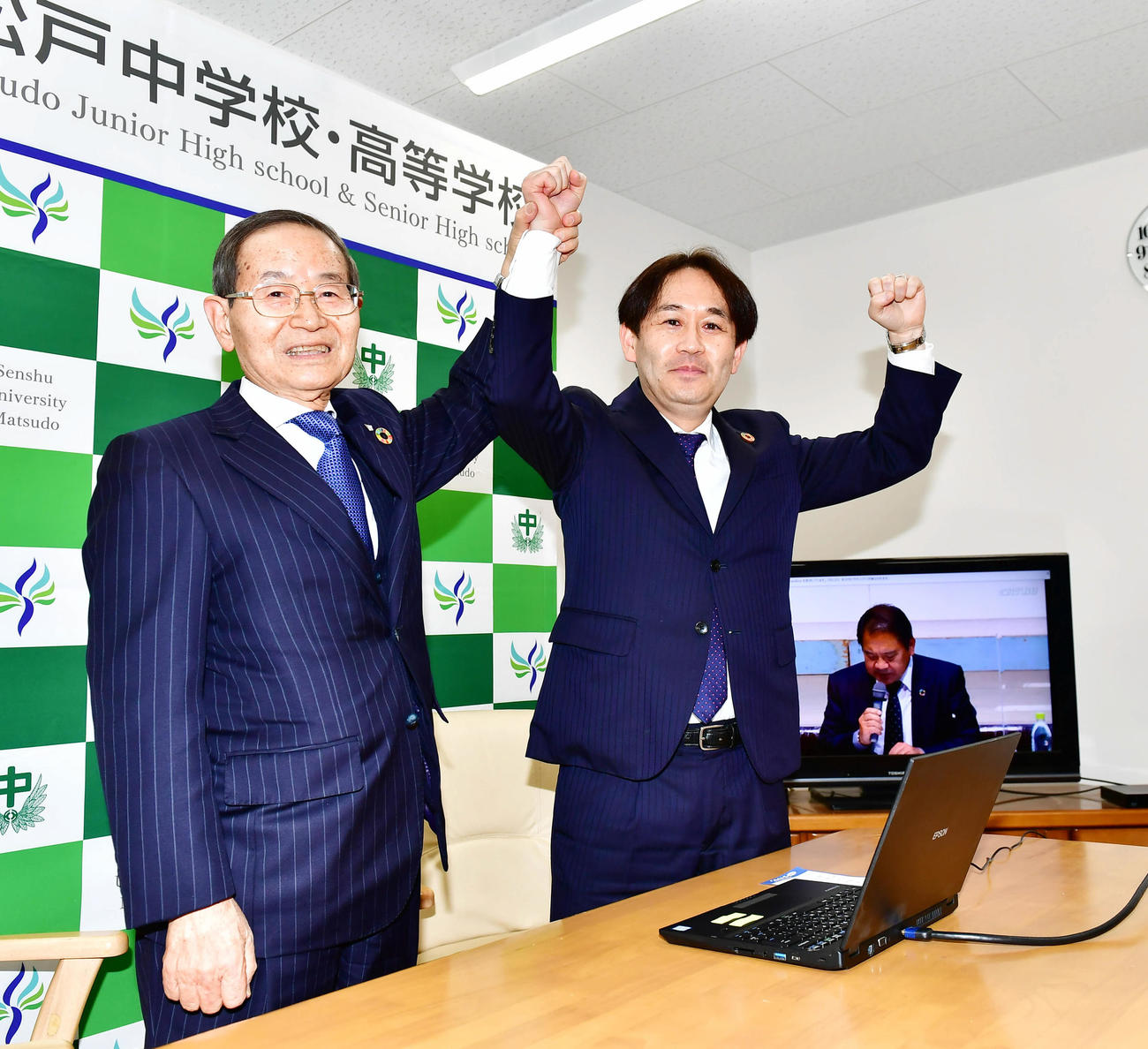 センバツ出場が決まりバンザイする専大松戸の富山理事長（左）と五味校長（撮影・小沢裕）