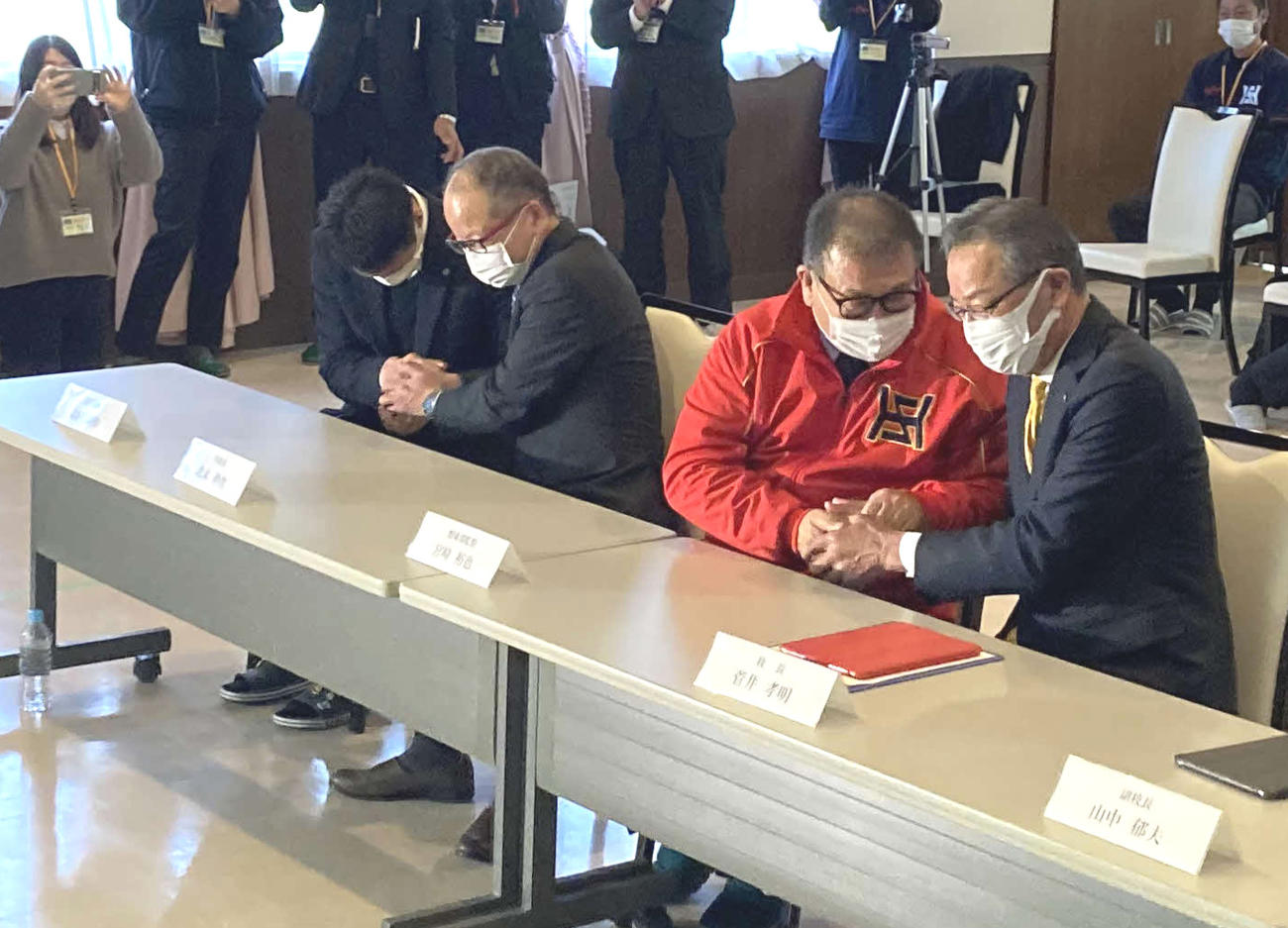 創立初の甲子園出場が決定し、菅井校長（右）と握手をする宮崎監督