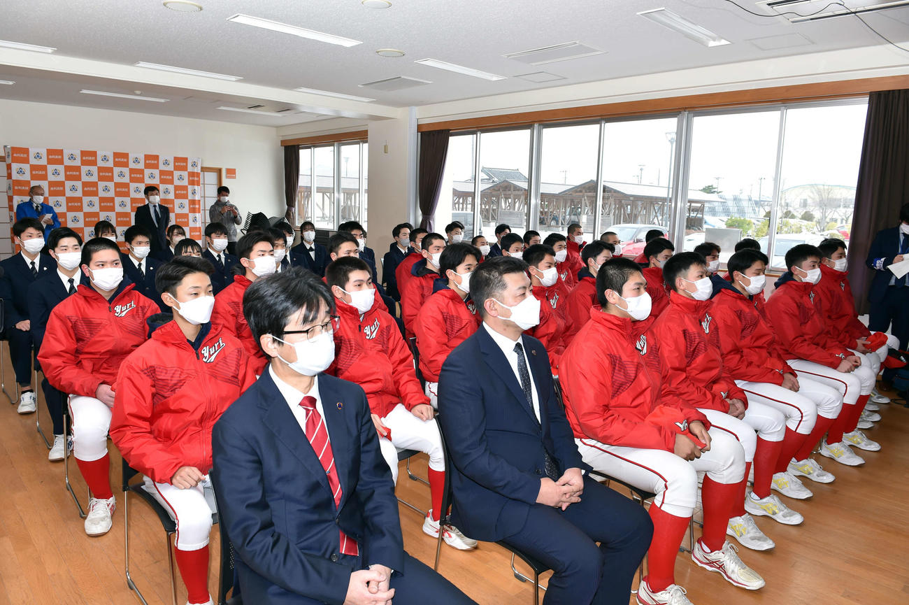 21世紀枠出場校を伝えるテレビ画面を見つめる由利・斉藤監督（前列左から2人目）とナイン