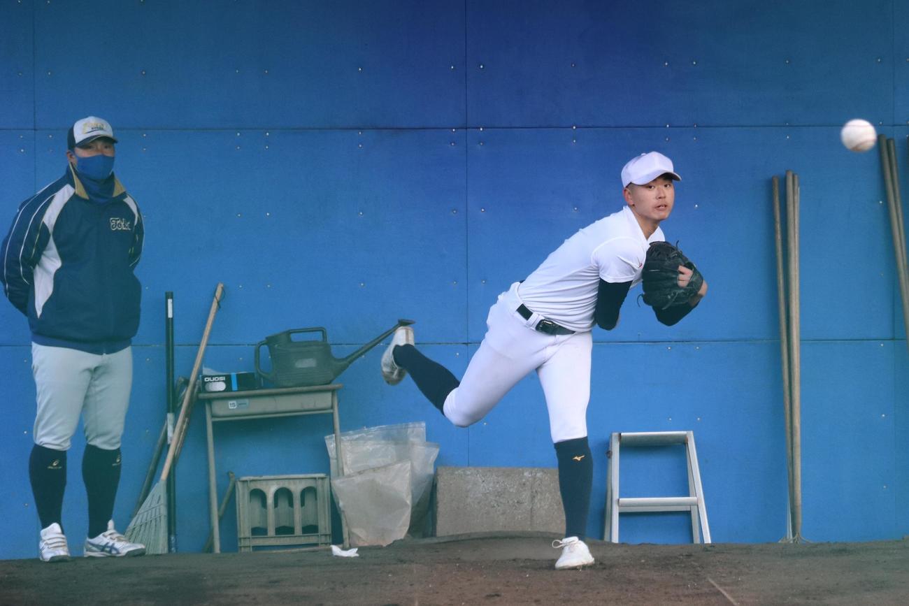 センバツ出場校発表翌日の練習で、（写真右）の宮本投手を指導する（写真左）東海大菅生の上田監督（撮影・保坂淑子）