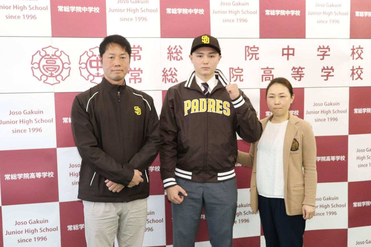 パドレスとのマイナー契約を結んだ報告会で、（左から）上園啓史日本担当スカウト、ガッツポーズを見せる常総学院・ブライアン、母・彩香さん（撮影・保坂淑子）