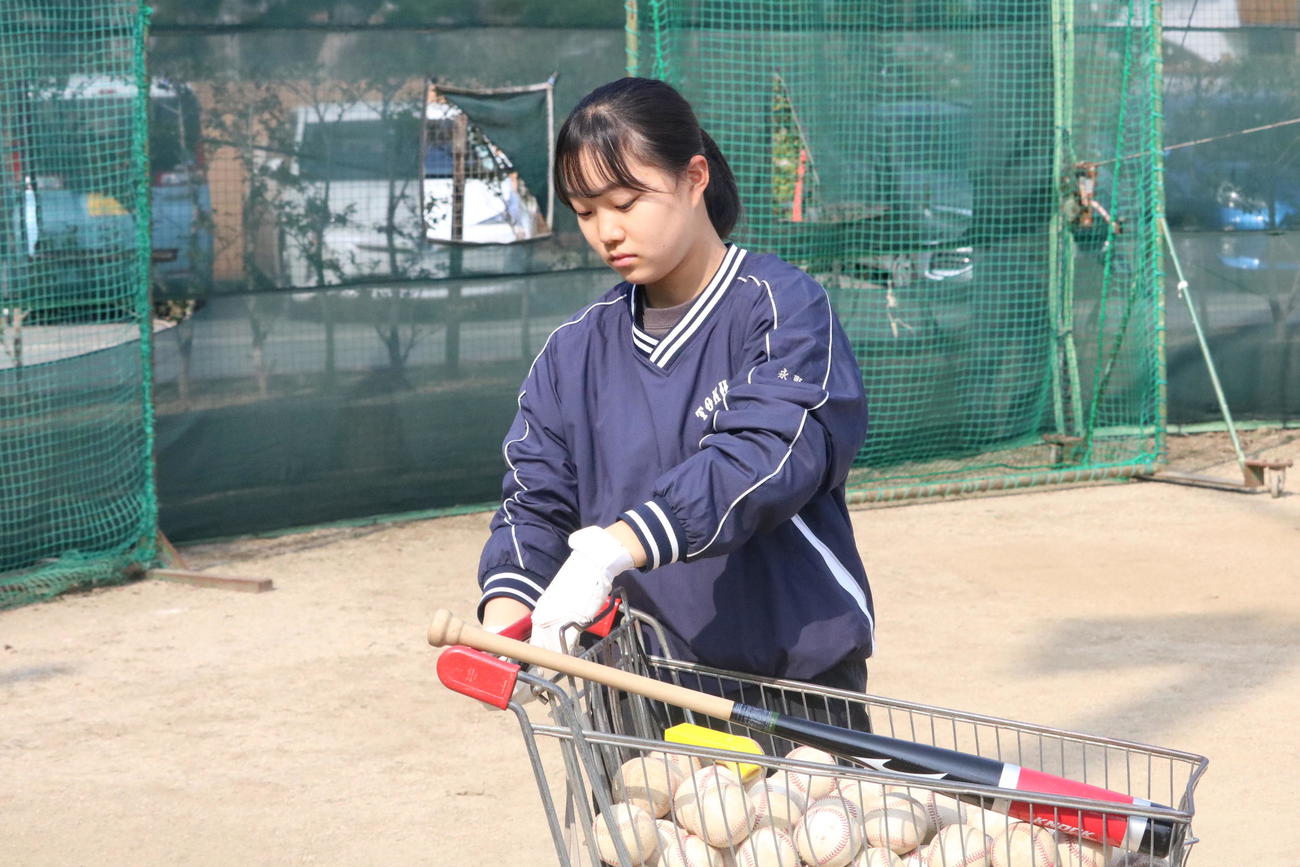 城東の永野悠菜マネジャー（3年）はノックの準備にとりかかる（撮影・林亮佑）＝2023年3月10日、城東高校グラウンド