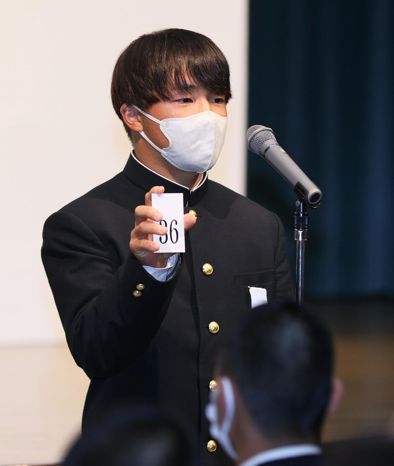 センバツ抽選会で引いた番号を発表する慶応の大村主将（撮影・上山淳一）