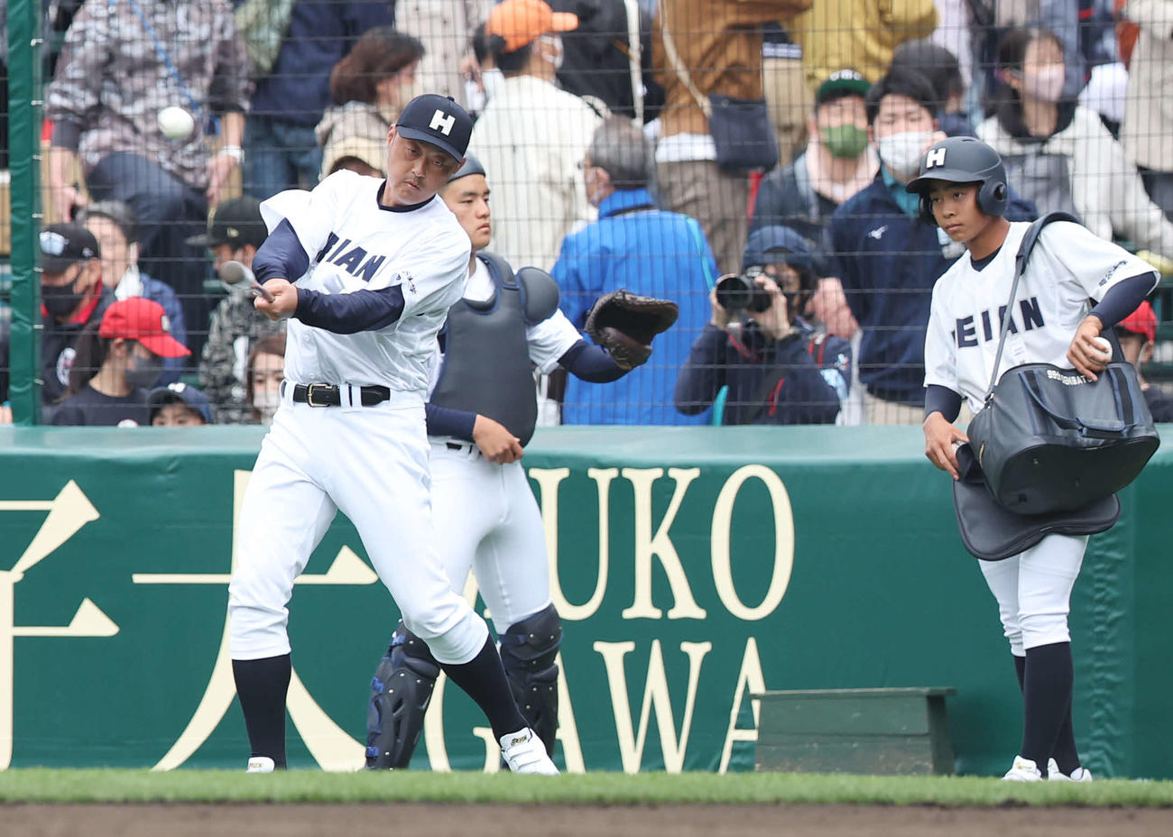 龍谷大平安対長崎日大　試合前ノックを打つ龍谷大平安・川口コーチ（左）（撮影・宮地輝）
