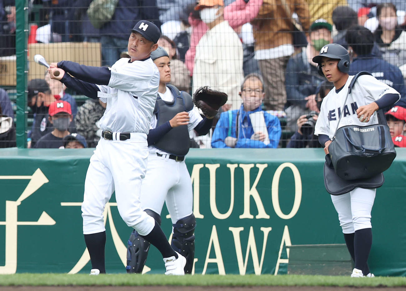 龍谷大平安対長崎日大　試合前ノックを打つ龍谷大平安・川口コーチ（左）（撮影・宮地輝）
