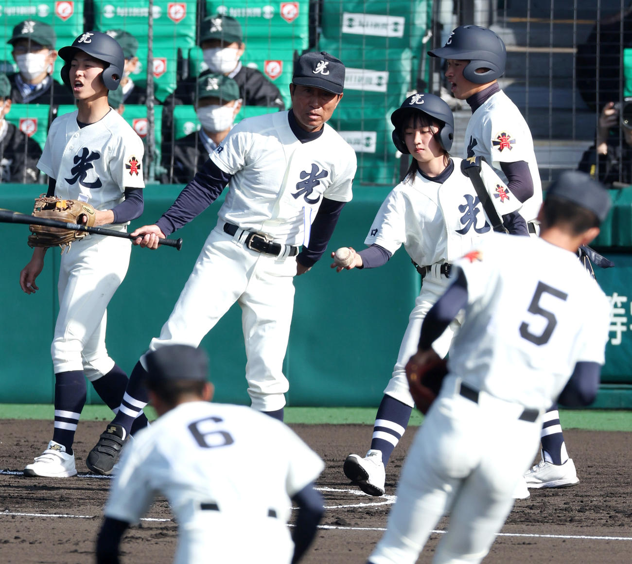 光対彦根総合　試合前のノックをする光の宮秋監督（左から2人目）にボールを渡す女子マネージャーの西原さくらさん（左から4人目）（撮影・上山淳一）