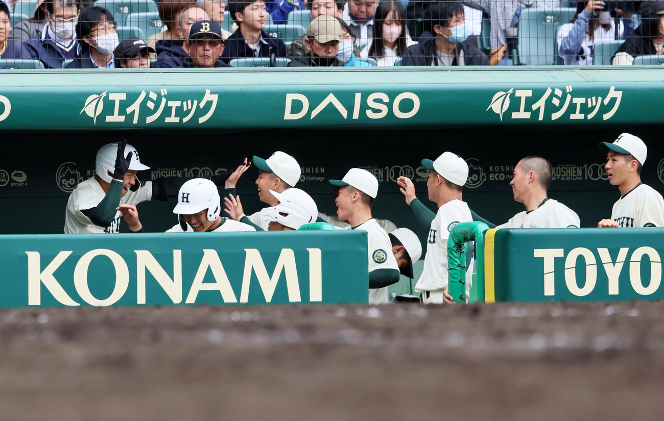 報徳学園対高崎健康福祉大高崎　8回表報徳学園2死三塁、石野（左）は左越え2点本塁打を放ち、ベンチで笑顔を見せナインとタッチする（撮影・加藤哉）