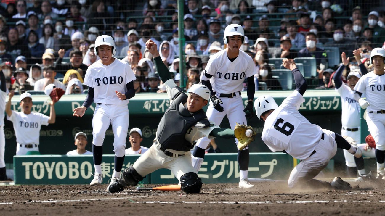 東邦対報徳学園　4回表東邦2死一、二塁、岡本の中前適時打で二走大島（右から3人目）が生還する。捕手堀（撮影・上山淳一）