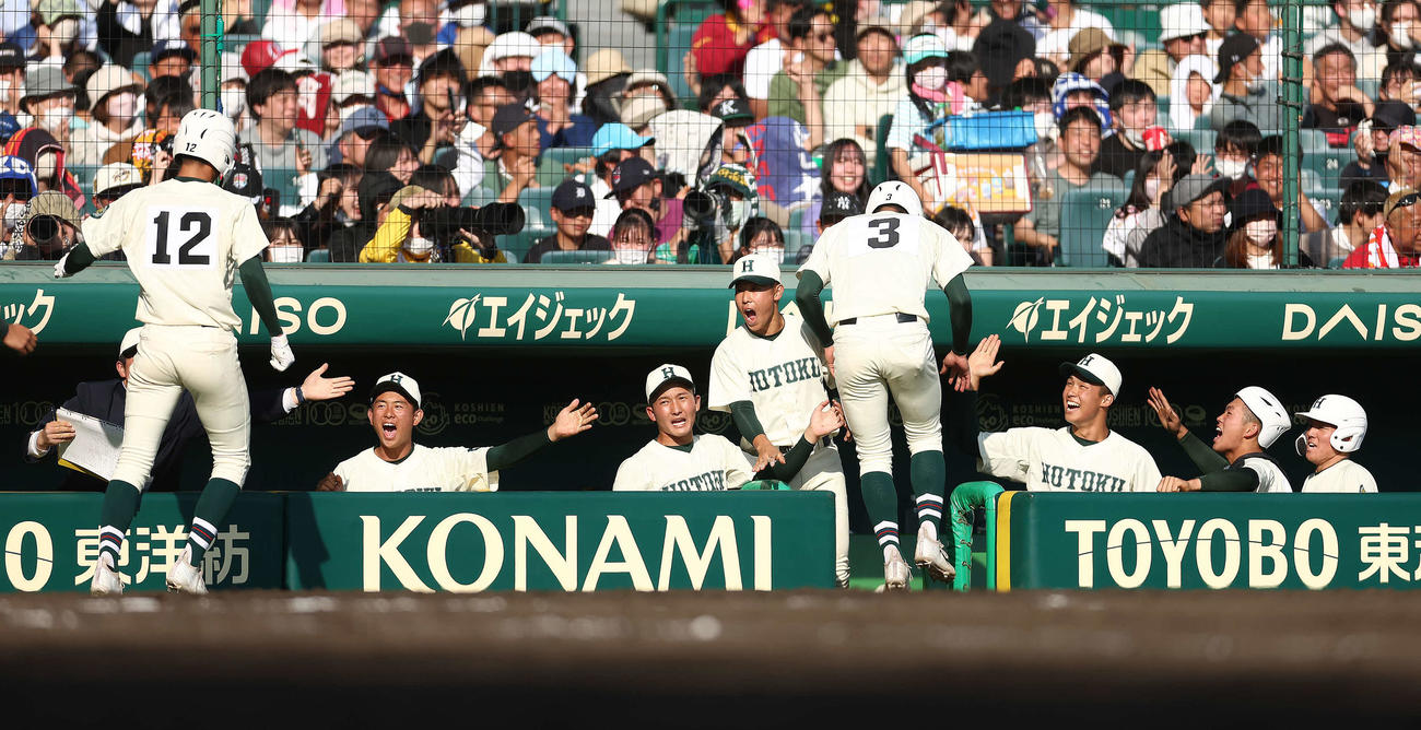 大阪桐蔭対報徳学園　7回裏報徳学園無死一、二塁、林の2点適時二塁打で生還する西村（左）と辻田を迎えるベンチナイン（撮影・河田真司）