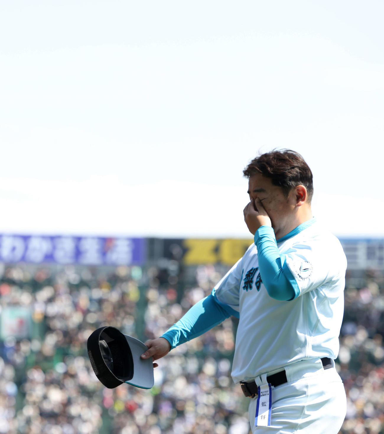 山梨学院対広陵　広陵に勝利し、決勝進出を決めた山梨学院・吉田洸二監督は、目頭を押さえながら引き揚げる（撮影・河田真司）