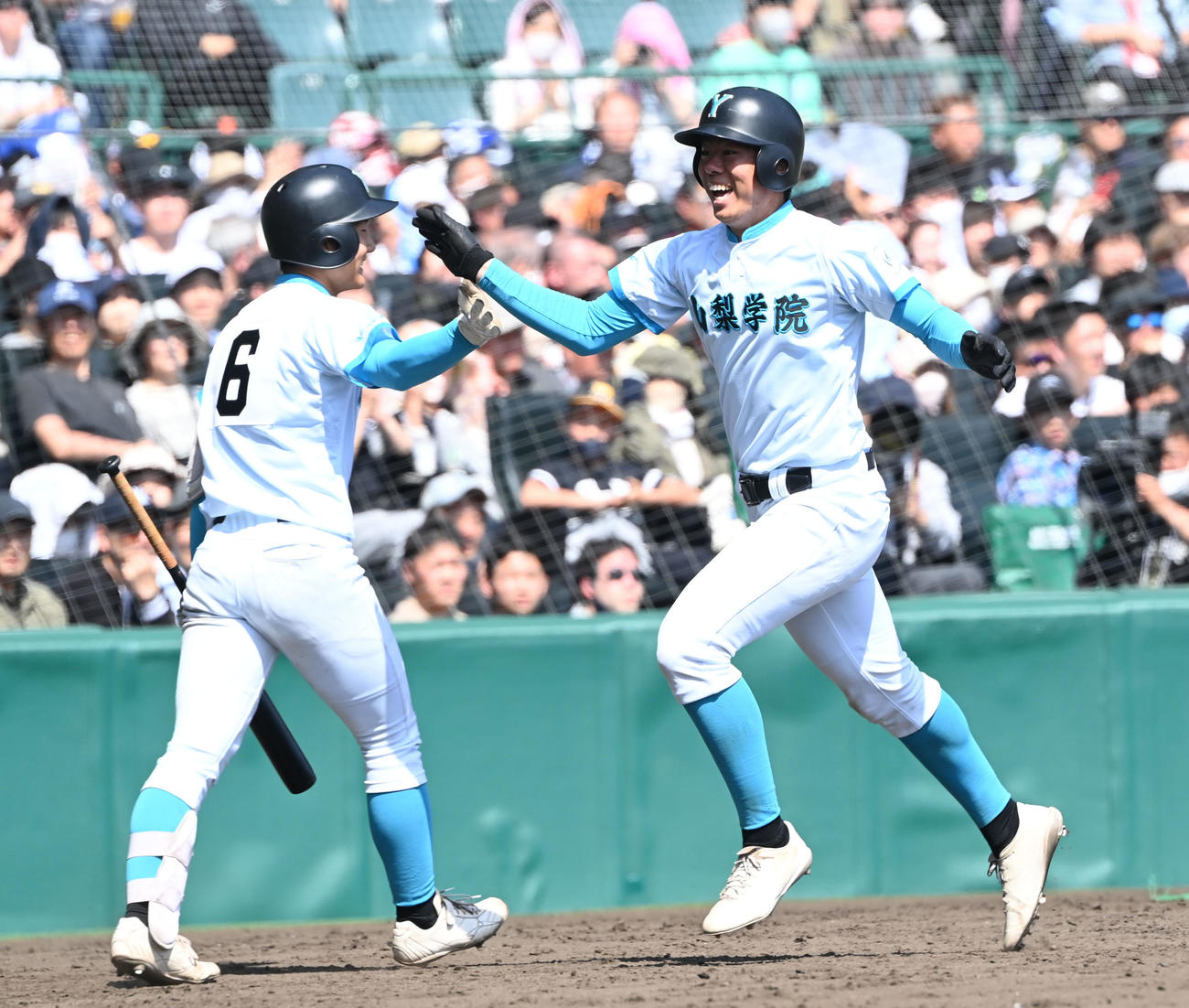 報徳学園対山梨学院　5回裏山梨学院2死二塁、左越えに本塁打を放った佐仲は笑顔で生還する（撮影・和賀正仁）