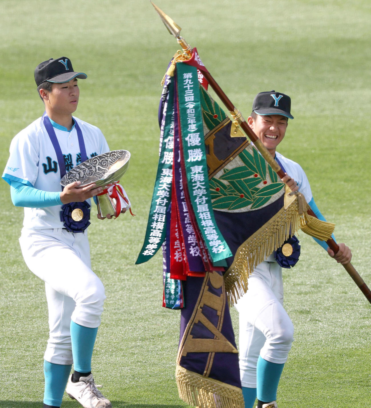 報徳学園対山梨学院　優勝旗を手に、笑顔をみせる山梨学院の進藤主将（右）。左は林（撮影・上山淳一）