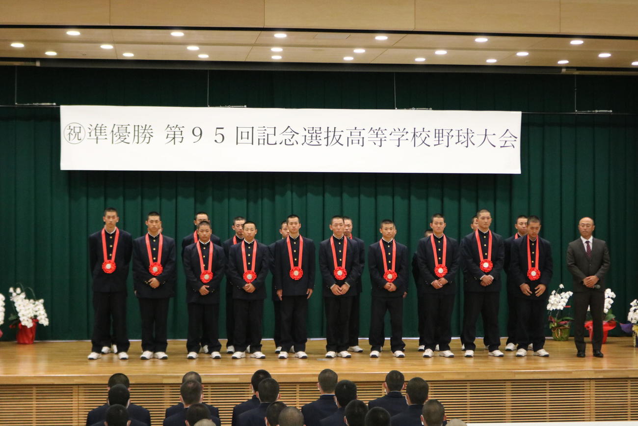 センバツ準優勝報告会で控え部員や保護者、学校関係者の前で整列する報徳学園のベンチ入りメンバーと大角健二監督（撮影・林亮佑）