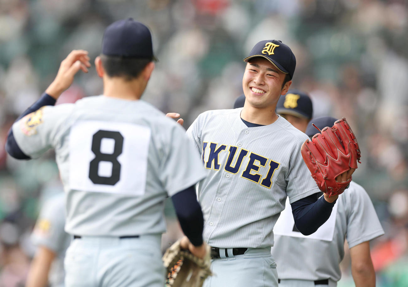 笑顔でナインを迎える仙台育英・高橋煌稀（右）（2023年3月29日撮影）