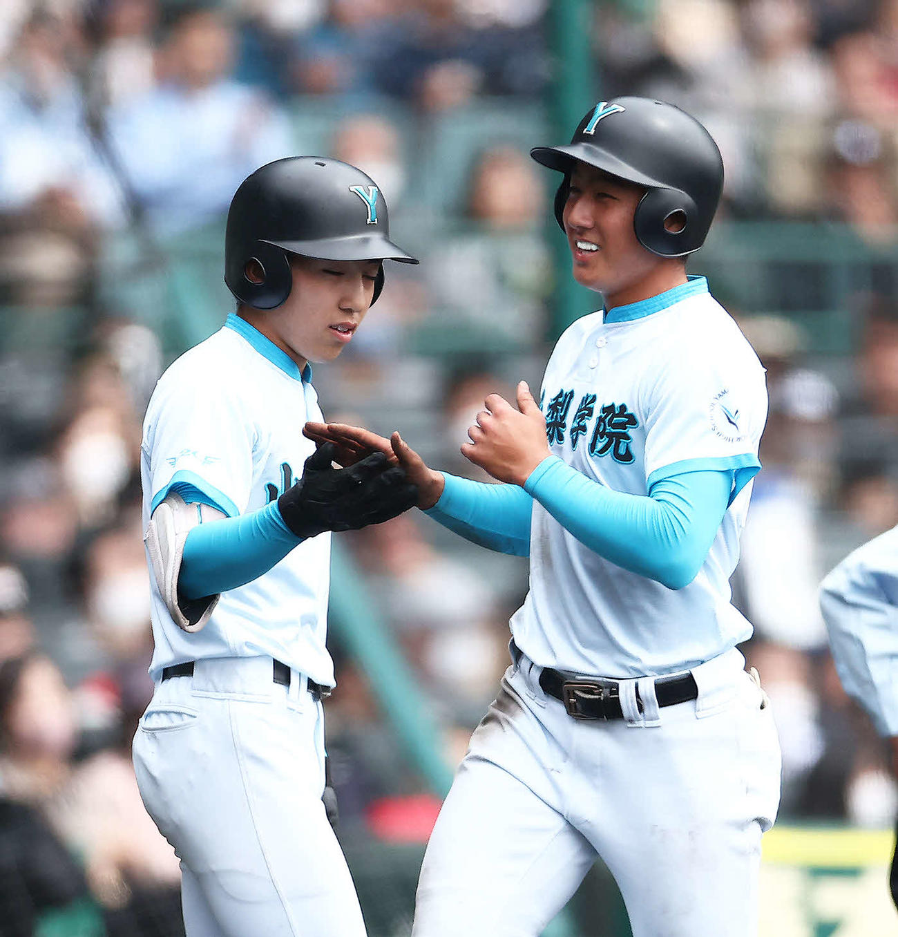 大森（左）とタッチを交わす山梨学院・高橋海翔（2023年3月31日撮影）