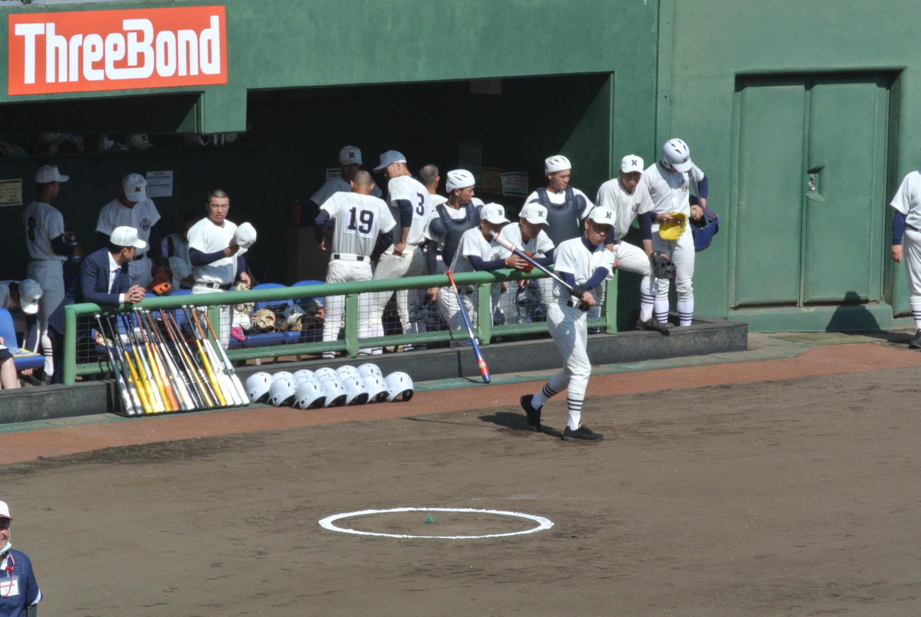 日大三の三木有造新監督は初陣となる都立青山戦を前にベンチ前で試合前ノックに備えてノックバットを振るう（撮影・井上真）