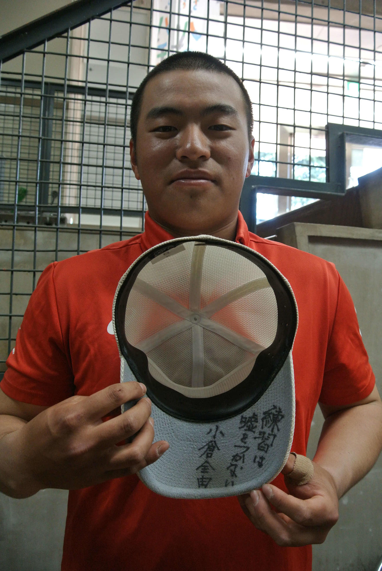 春季大会初戦となった2回戦都立青山にコールド勝ちした日大三の主将二宮士（まもる）内野手は、3月31日に小倉全由前監督に書いてもらった帽子のつばのサインを見せる（撮影井上真）